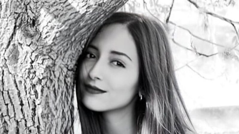 Mujer joven apoyada en un árbol