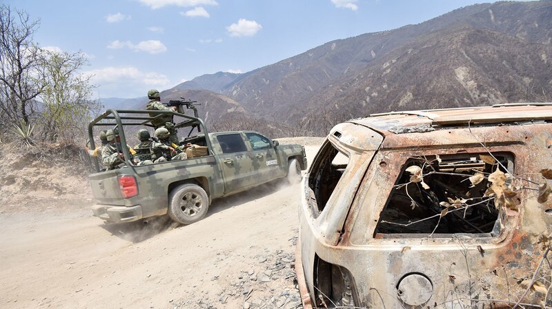 Militares mexicanos patrullan una carretera en una zona rural.