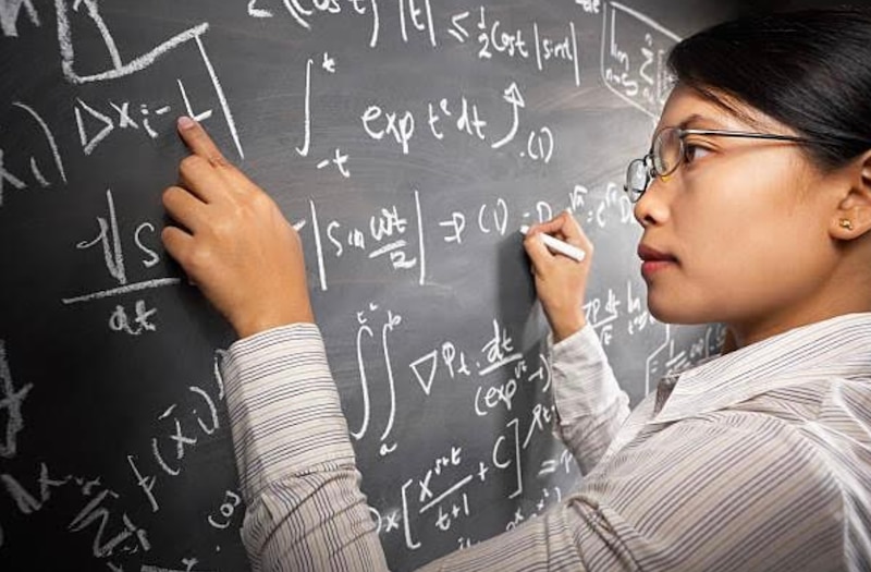 Profesora de matemáticas escribiendo en la pizarra