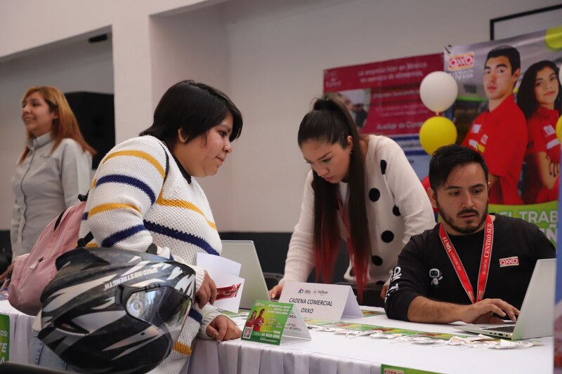 Title: Estudiantes en una feria de empleo buscando trabajo
