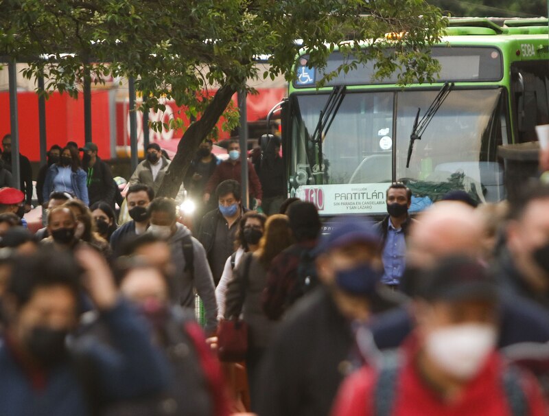 Multitud de personas esperando el autobús en una parada