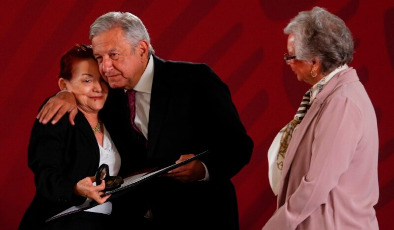 El presidente López Obrador entrega un reconocimiento a una mujer indígena