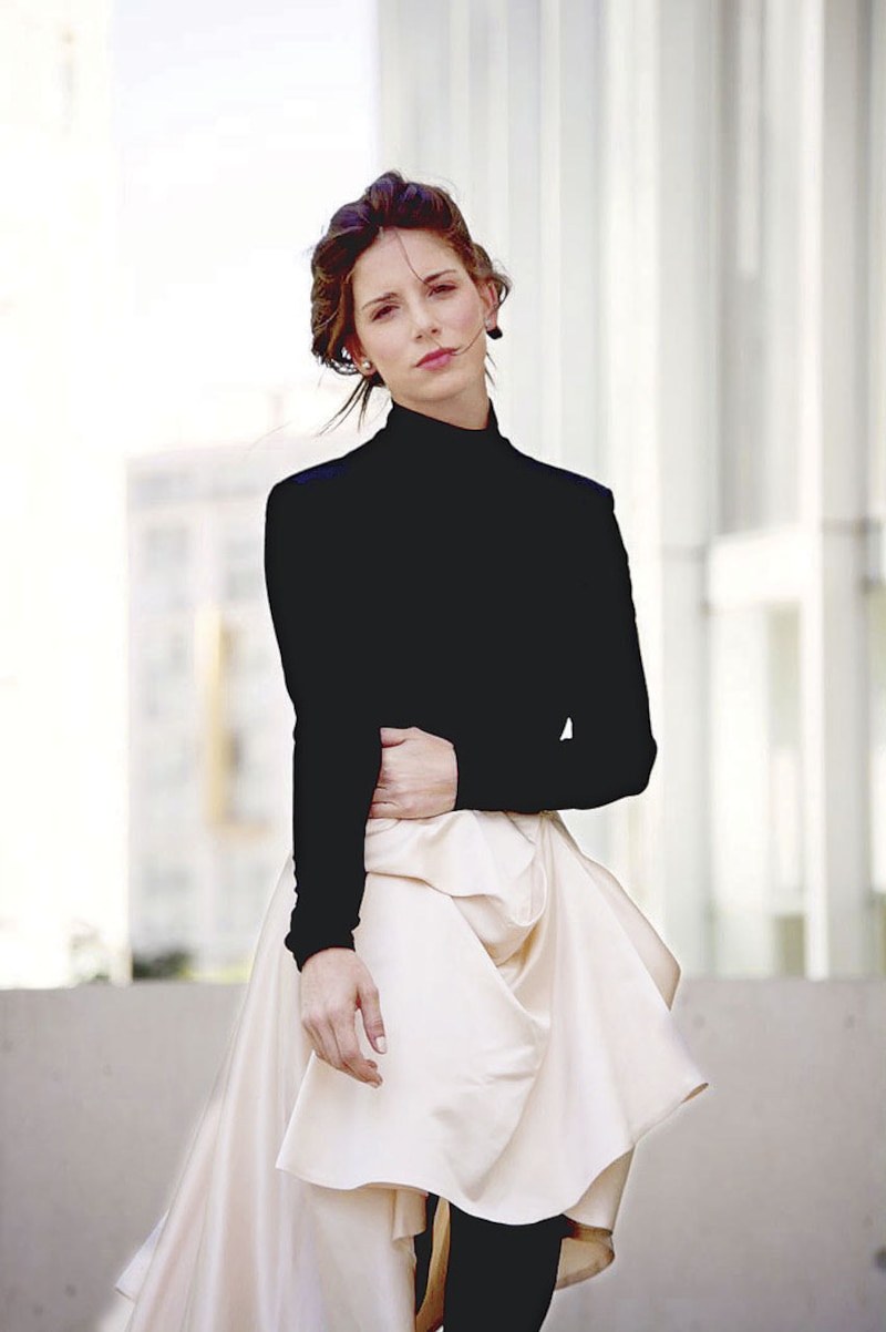 Elegante mujer joven con vestido negro y falda blanca