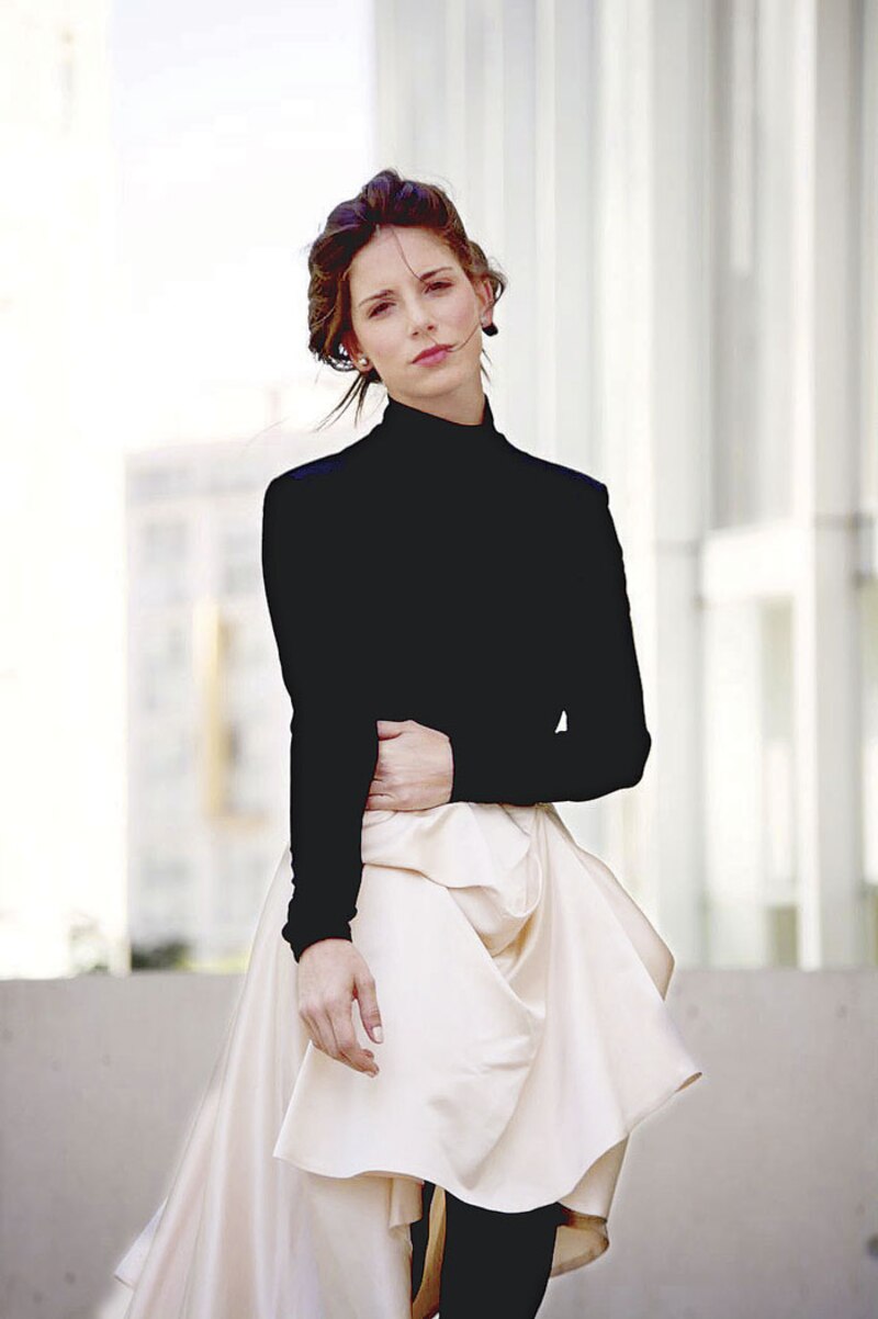 Elegante mujer joven con vestido negro y falda blanca