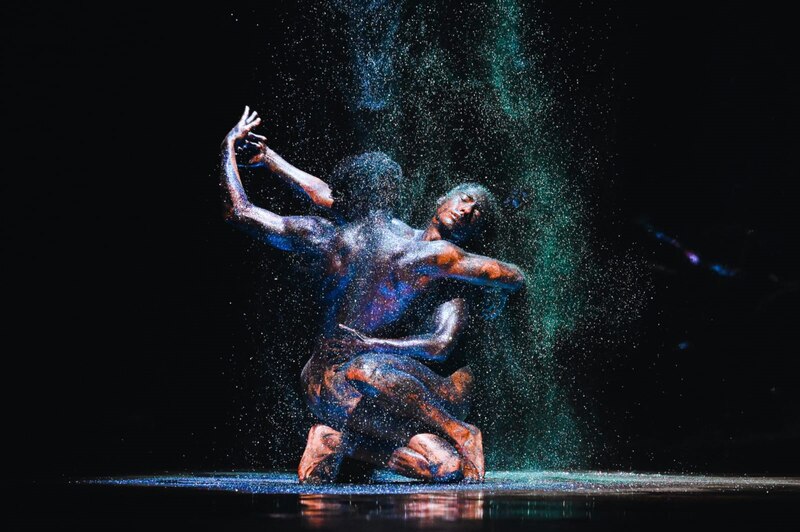 Pareja de bailarines realizando una coreografía bajo una lluvia de brillantina.