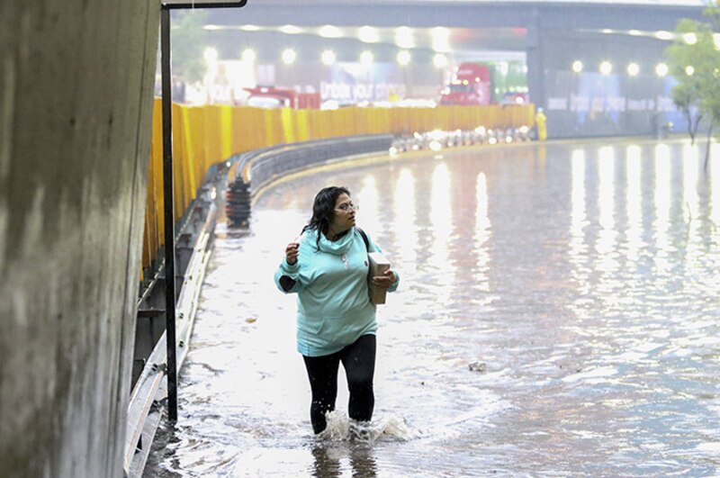 Mujer camina por una calle inundada