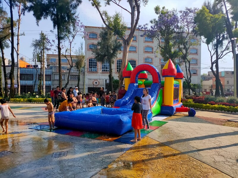 Niños jugando en un parque acuático inflable