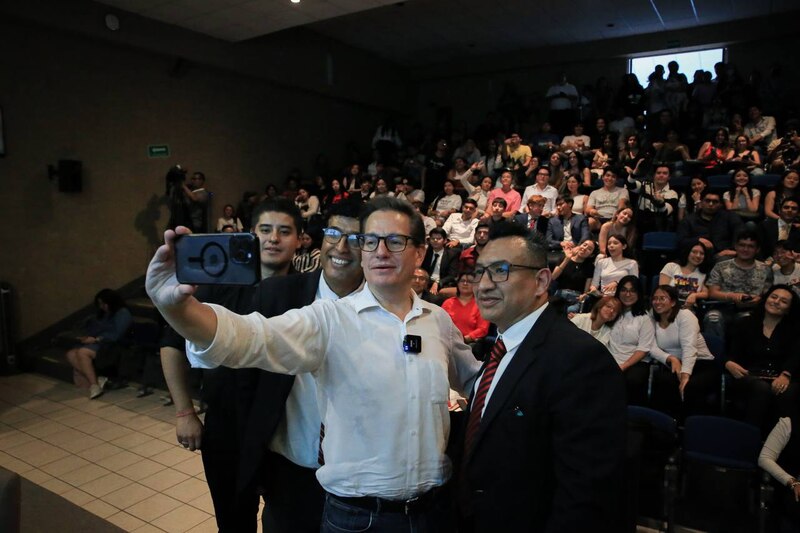 El presidente de México, Andrés Manuel López Obrador, se toma una selfie con estudiantes en un evento público.