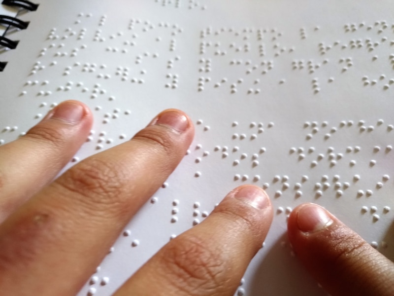 Manos leyendo un texto en sistema Braille