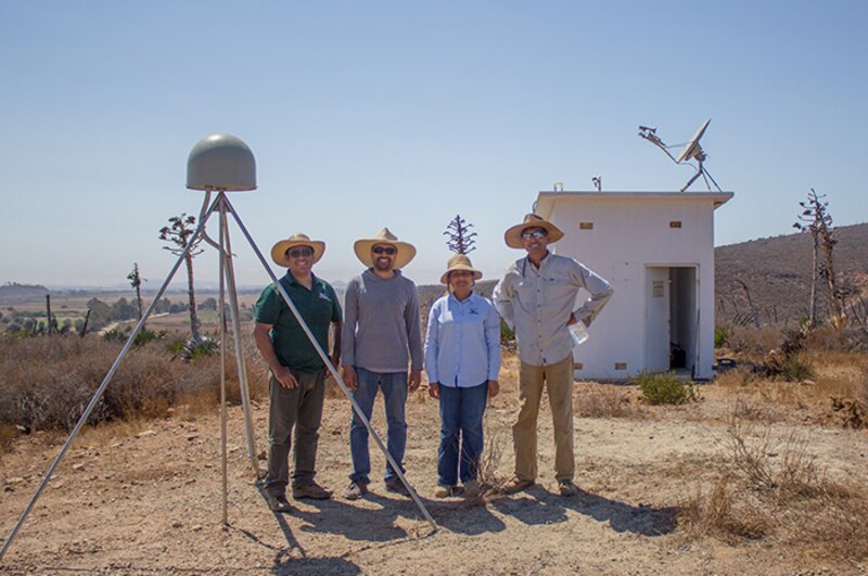 Científicos instalando una estación meteorológica en una zona rural