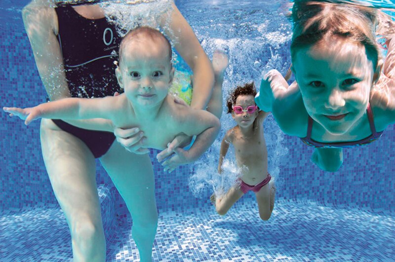 Bebés y niños nadando en una piscina