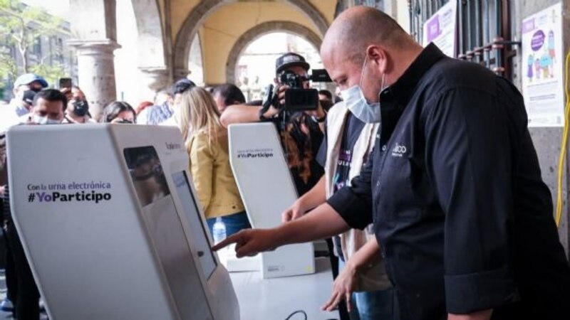 Un hombre usando una máquina de votación electrónica.