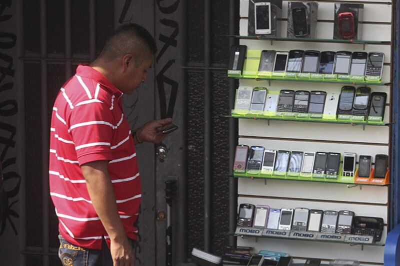 Un hombre mirando los teléfonos móviles en una tienda