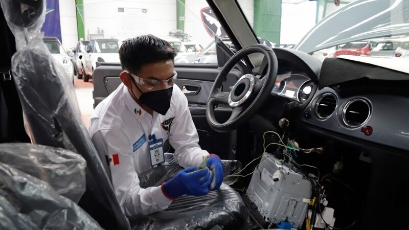 Un mecánico trabaja en el interior de un automóvil.