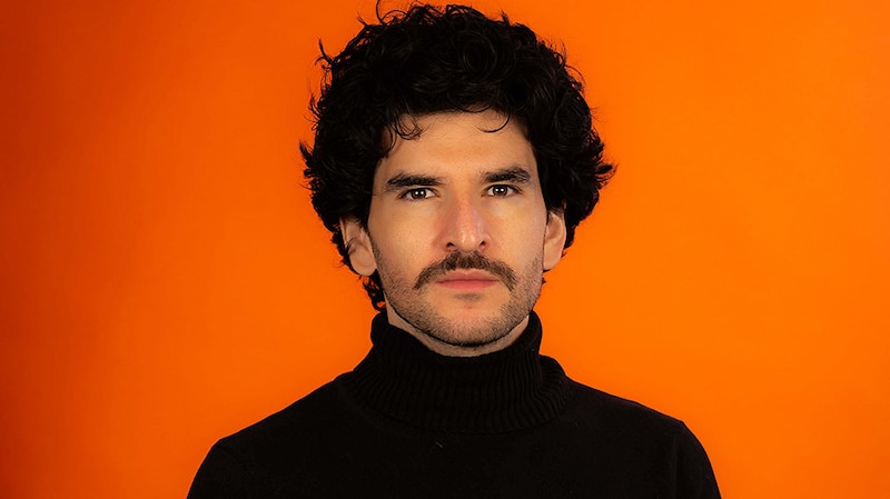 Joven con bigote y pelo rizado