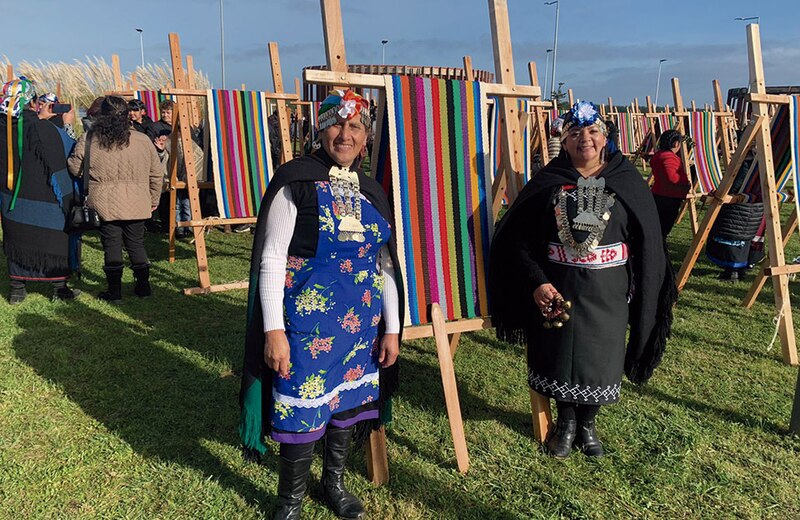 Mujeres indígenas tejiendo en un telar tradicional