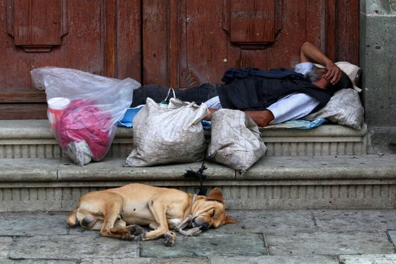Un hombre y su perro sin hogar duermen en la calle