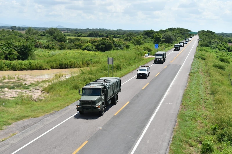 Convoy de camiones militares en una carretera rural