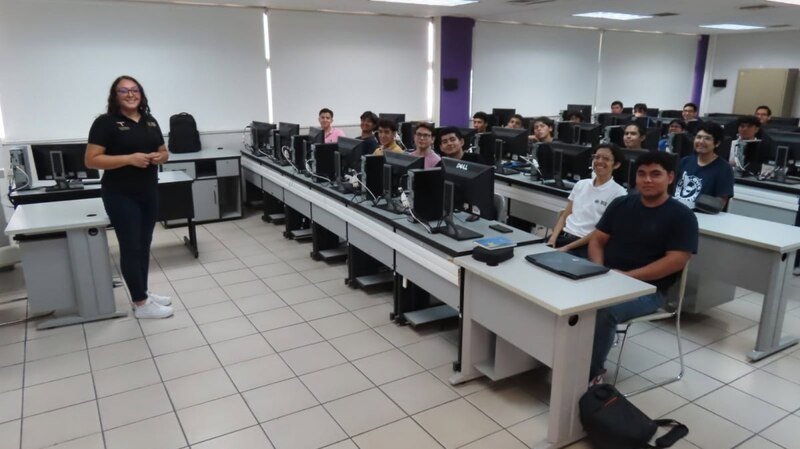 Estudiantes de preparatoria escuchando atentamente a su profesora en el aula