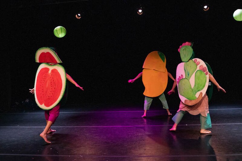 Personas bailando con disfraces de frutas