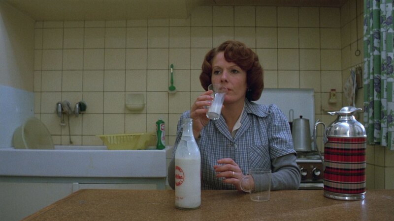 Mujer tomando leche en la cocina