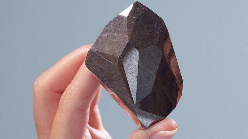 Una mano sujetando una piedra preciosa