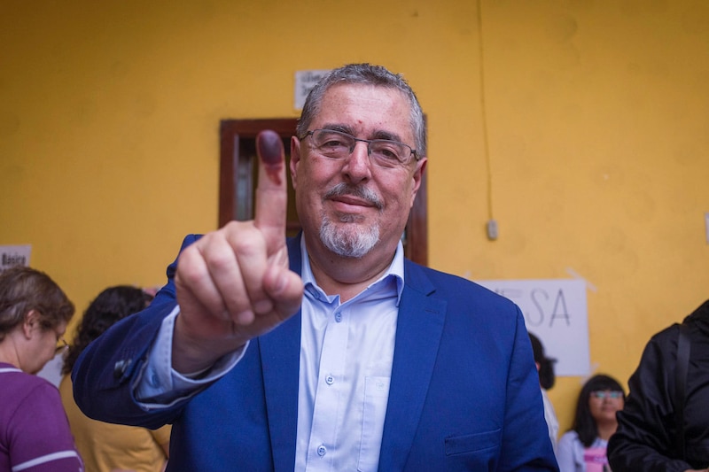 Político muestra su dedo pulgar manchado de tinta después de votar