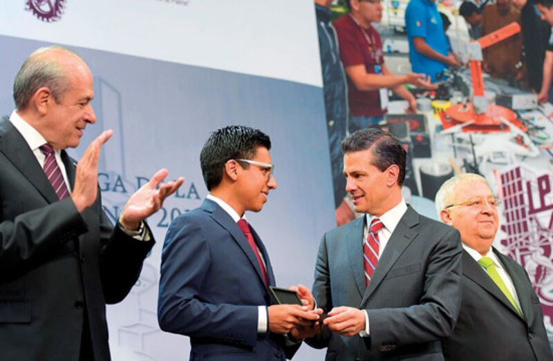 El Presidente de México entrega un premio a un joven estudiante.