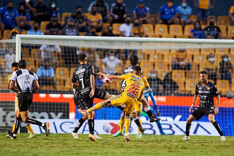 Jugador de fútbol dispara el balón hacia la portería