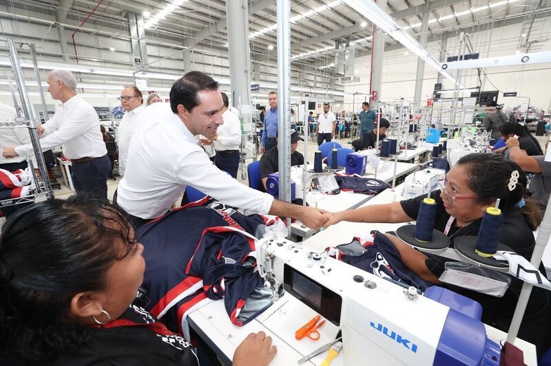 El presidente de México, Enrique Peña Nieto, saluda a una trabajadora de una fábrica textil.