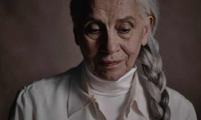 Retrato de una mujer mayor con cabello blanco y ojos azules.