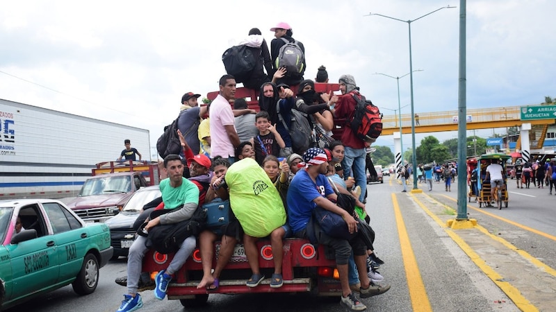 Migrantes centroamericanos viajan en la parte trasera de un camión en su camino hacia la frontera con Estados Unidos.