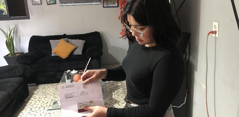 Mujer joven sosteniendo una tarjeta de identificación