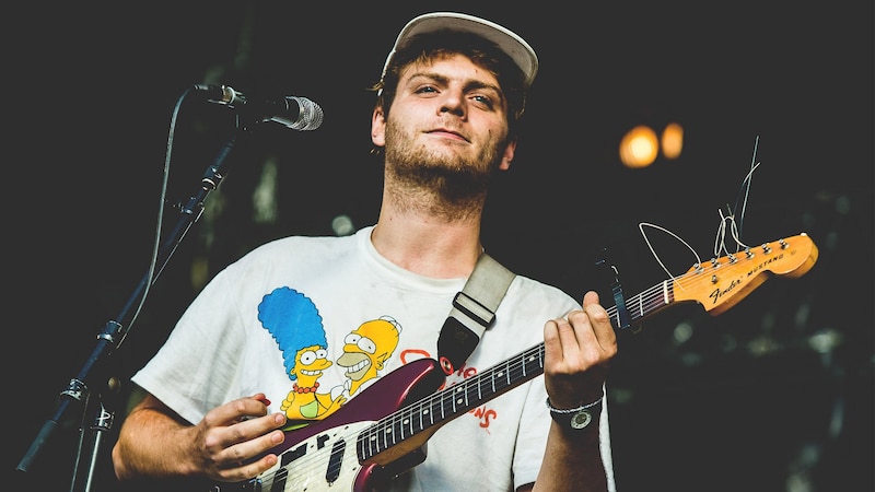 El músico Mac DeMarco tocando la guitarra en un concierto