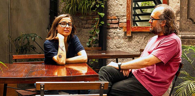Pareja sentada en una mesa de madera en un patio