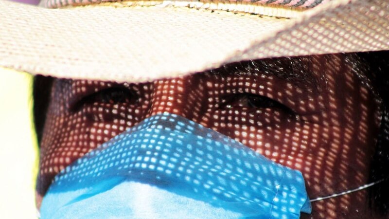 Un hombre con sombrero y mascarilla