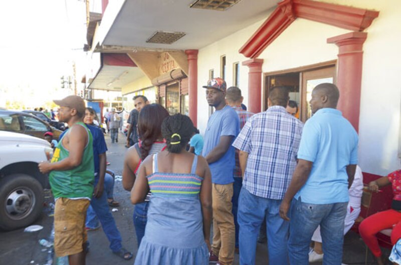 Larga fila de personas esperando para entrar a un comercio