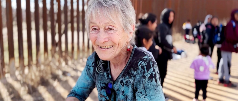 Abuela sonríe ante la valla fronteriza