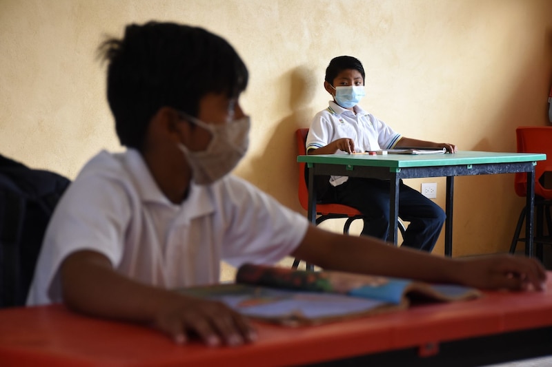 Niños con mascarillas en el aula