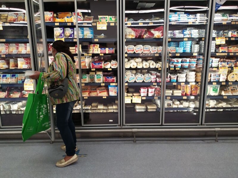 Mujer comprando queso en el supermercado