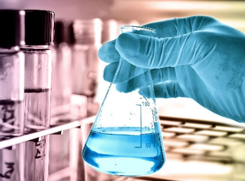 Científico sosteniendo un matraz con líquido azul