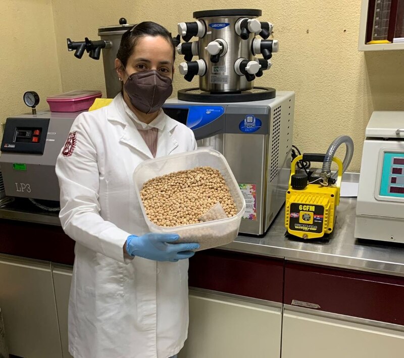Investigadora sosteniendo un recipiente con garbanzos