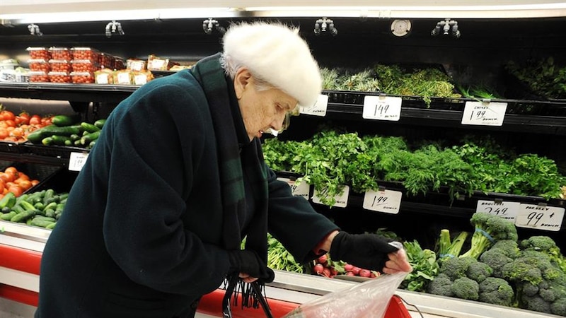 Mujer mayor comprando verduras en el supermercado