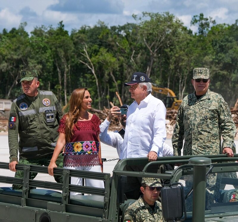 El presidente López Obrador saluda a la gente desde un vehículo militar