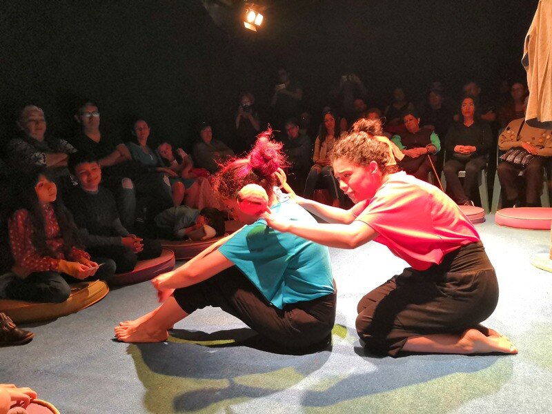 Dos mujeres realizan una danza contemporánea en un escenario.