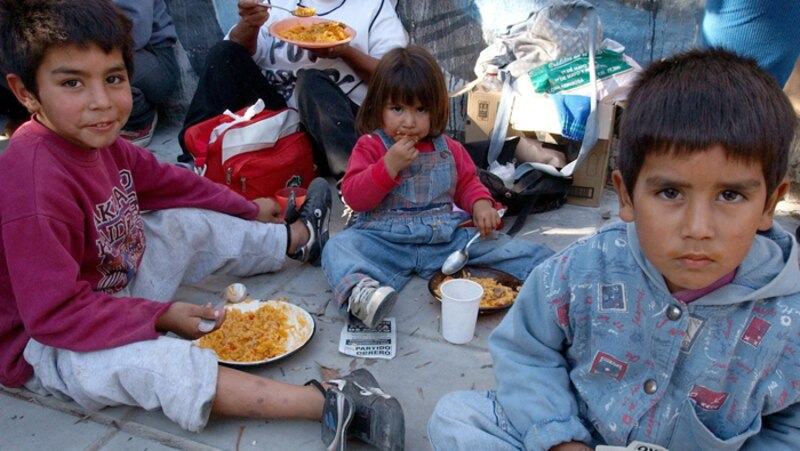 Niños pobres comiendo en la calle