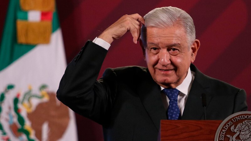 El presidente López Obrador se rasca la cabeza durante una conferencia de prensa.