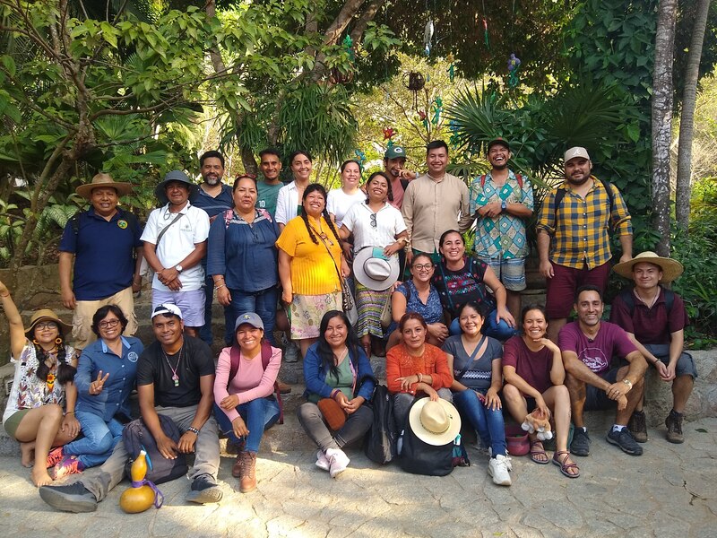 Un grupo de personas sonríe para una foto en un jardín.