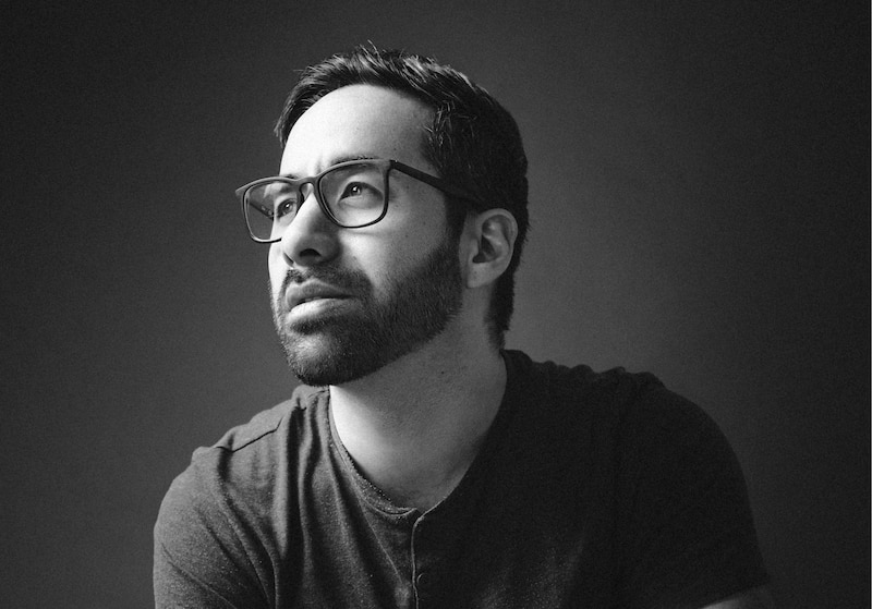 Retrato en blanco y negro de un hombre barbudo con gafas