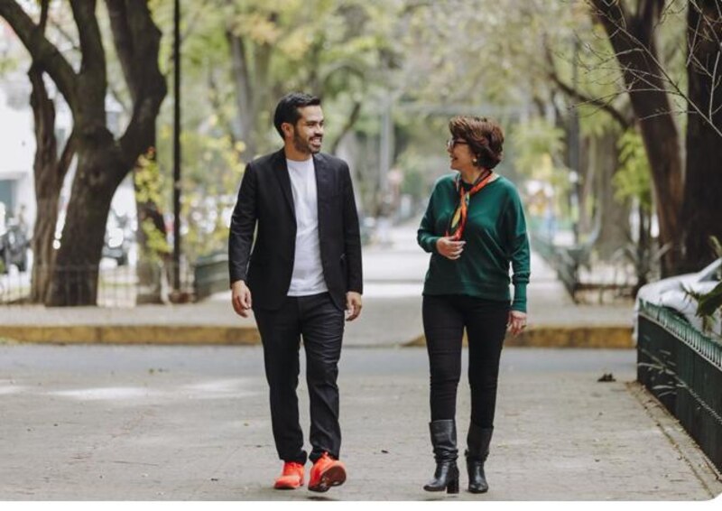 Dos personas caminando y hablando en un parque